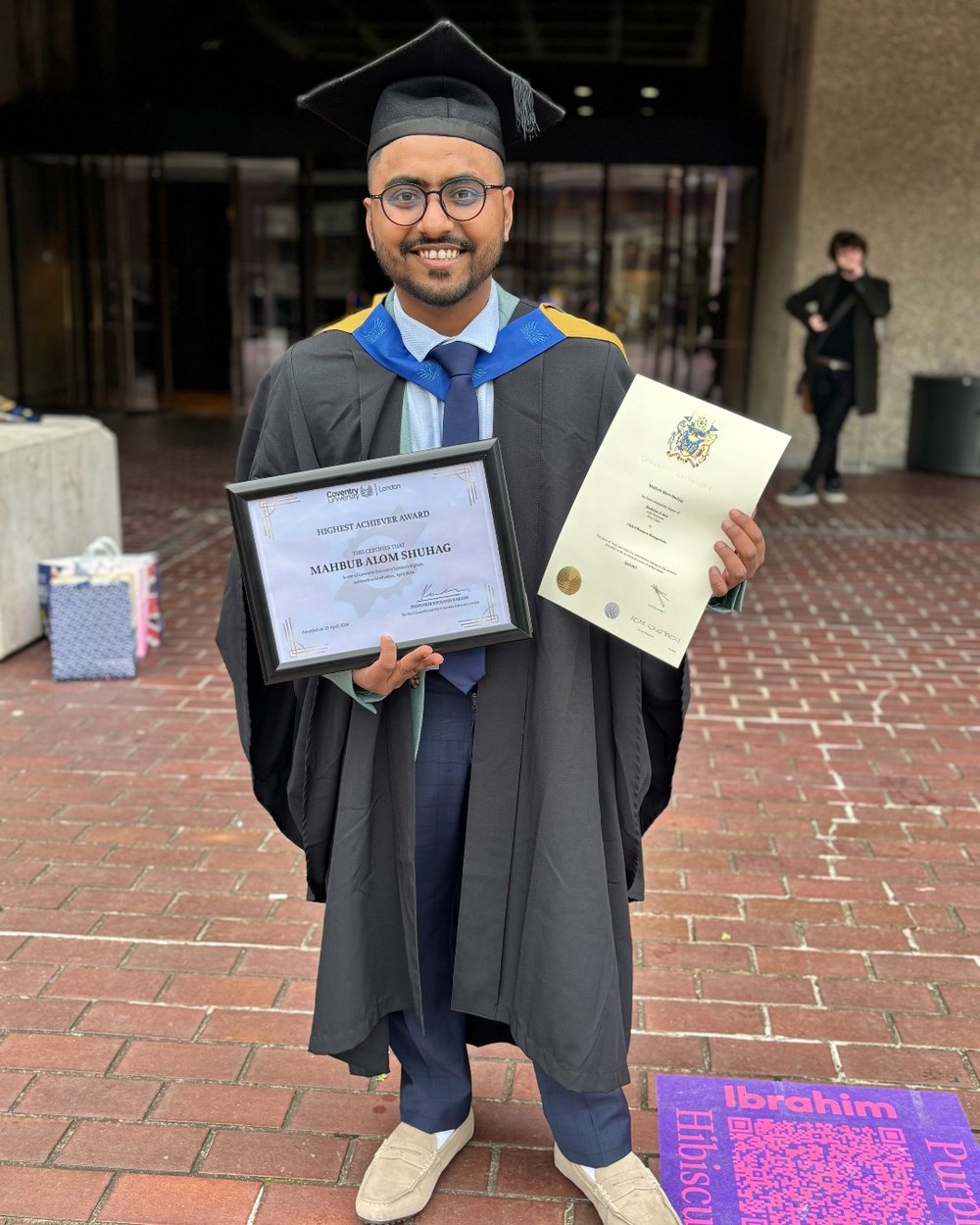 Mahbub Alom Shuhag at graduation holding his Highest Achiever Award